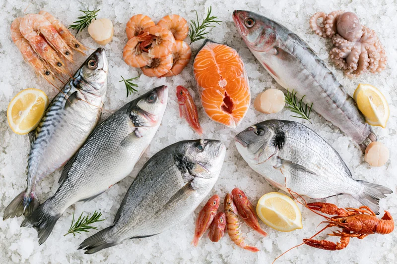 Assorted fresh raw seafood arranged on crushed ice with lemon and herbs