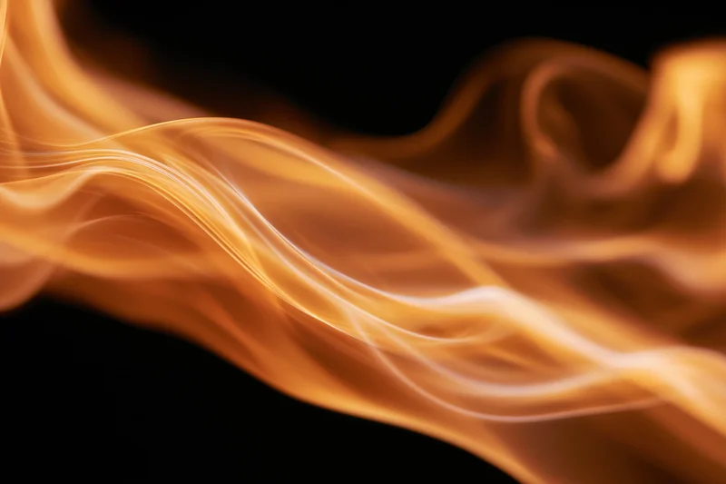 Flowing fire and smoke wisps in motion against a black background