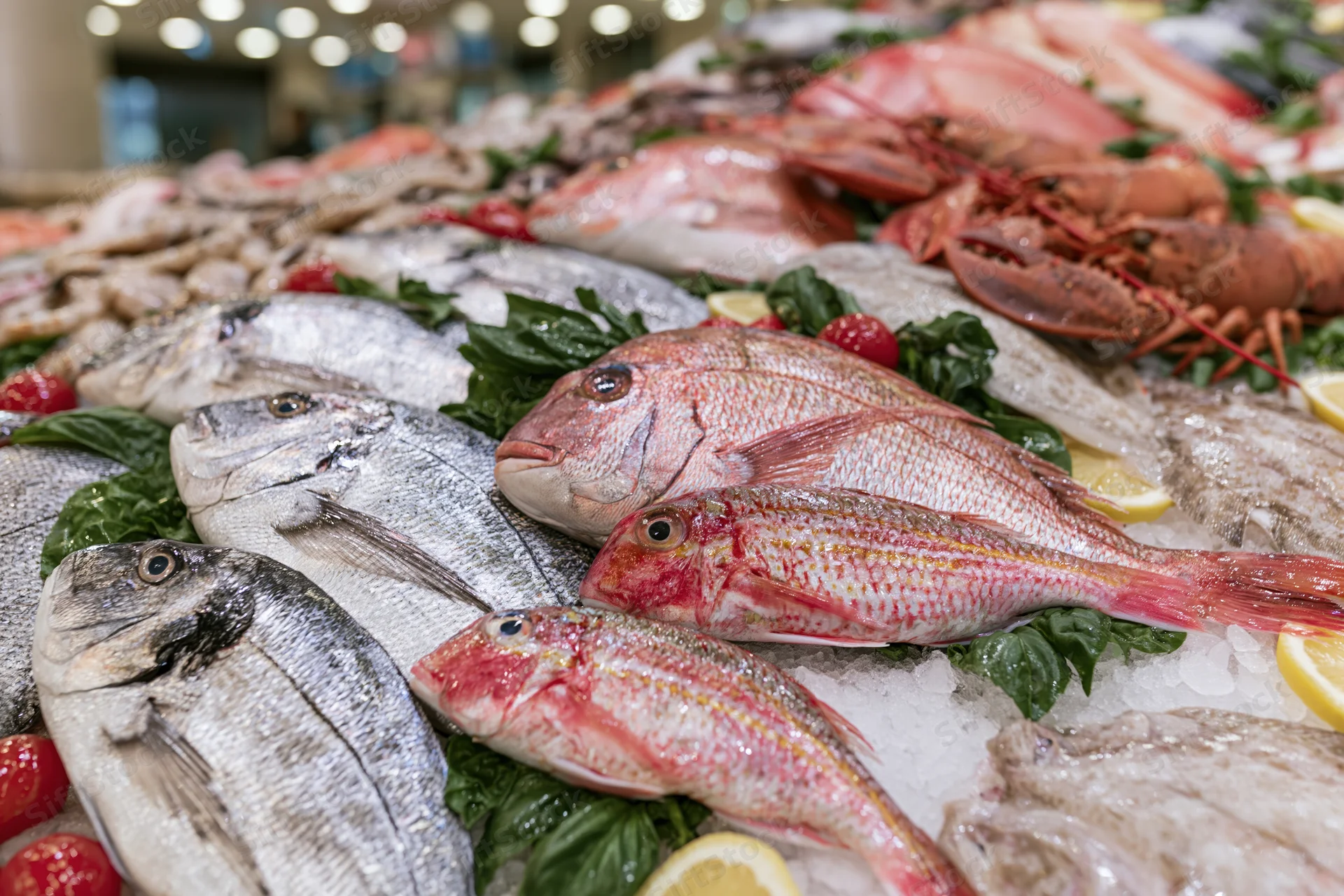 Whole fish and shellfish arranged on ice with garnishes at a seafood market display