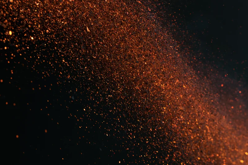 Glowing orange sparks flying through dark space in dynamic burst