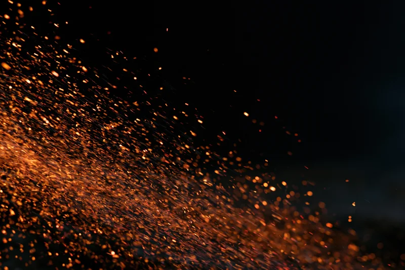 Glowing sparks flying through dark space in dynamic motion