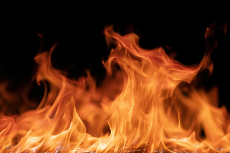 Intense flames burning against a black background with copyspace at the top