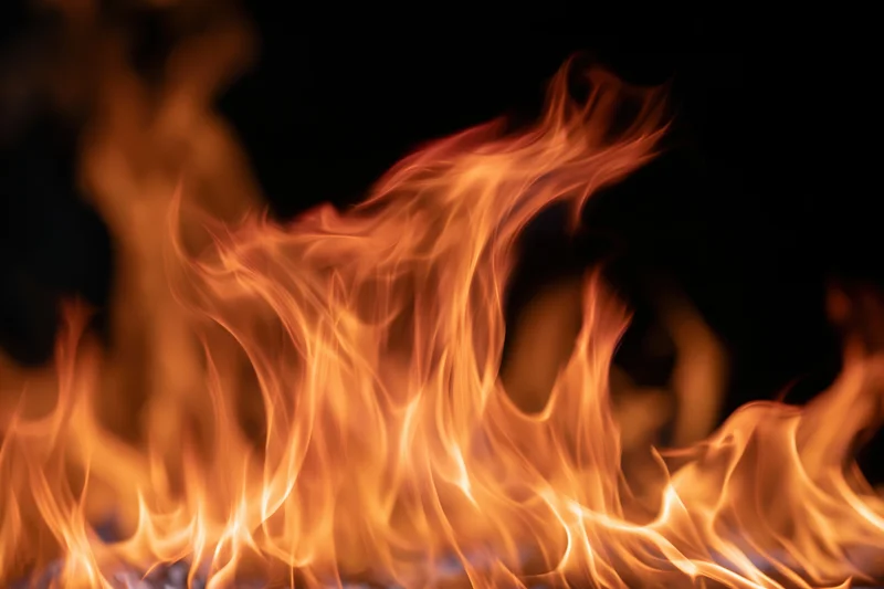 Intense orange flames burning against a pure black background