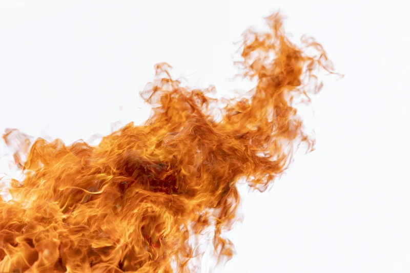 Fire flames burning upward against a pure white background