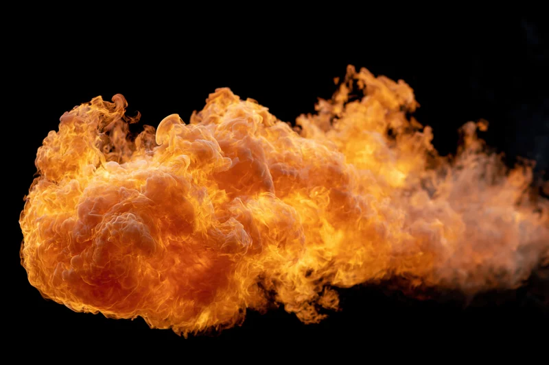 Large burst of open flame spreading horizontally against a black background
