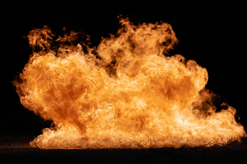 Large burst of open flame spreading horizontally against a black background