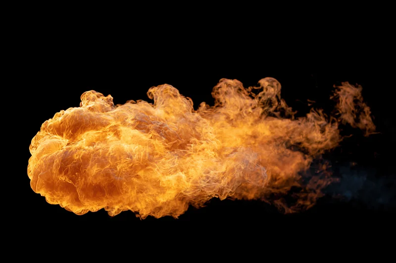 Large burst of open flame spreading horizontally against a black background