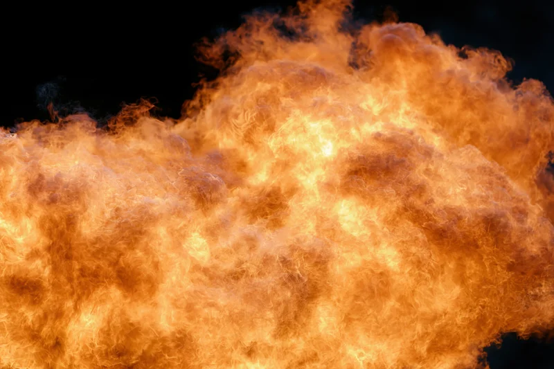 Large burst of open flames spreading horizontally against black background