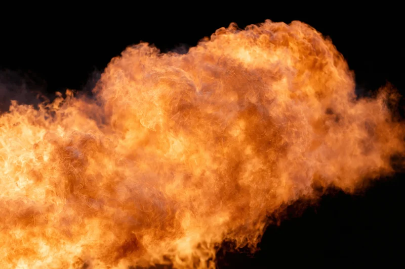 Large burst of open flames spreading horizontally against black background
