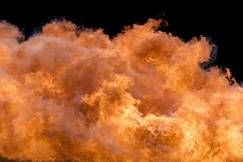 Large burst of open flames spreading horizontally against black background