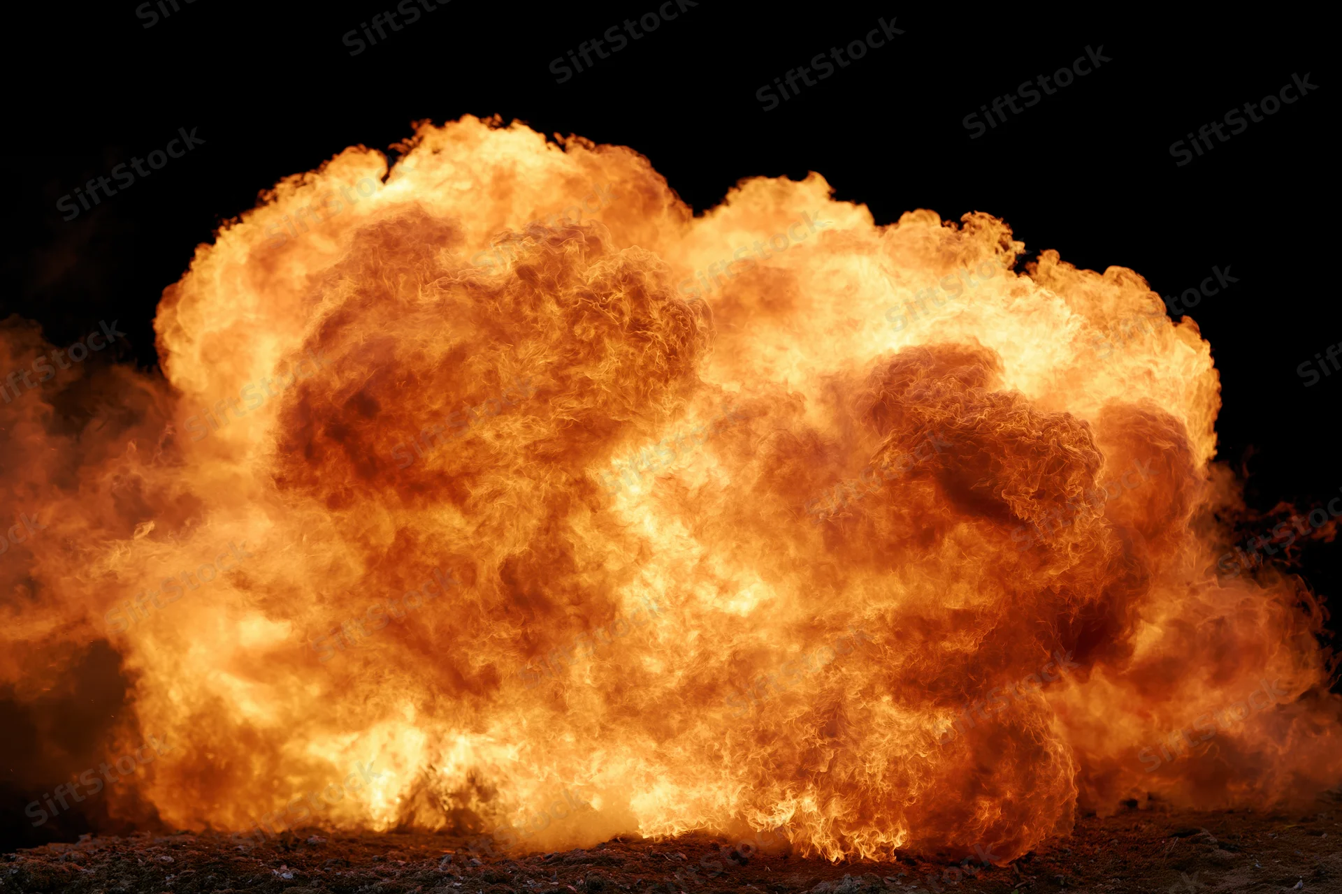 Large burst of flames spreading horizontally against black background