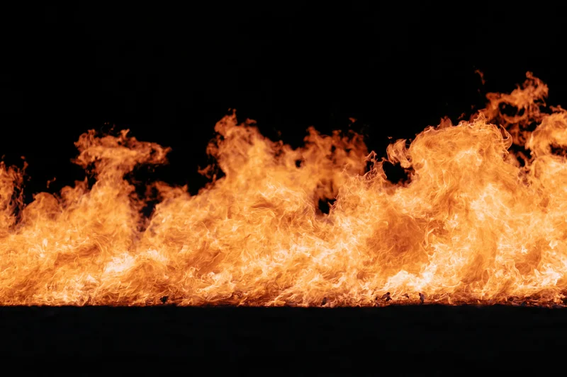 Intense flames burning horizontally against a pure black background