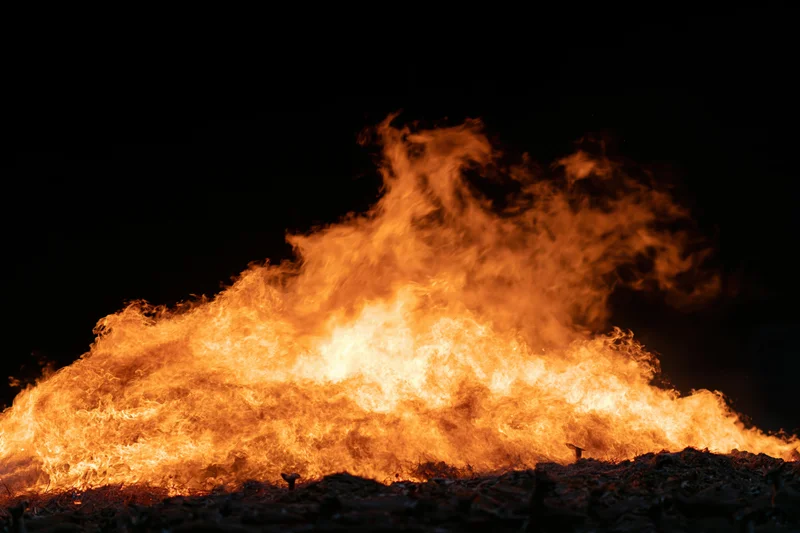 Intense fire burning brightly against a black night sky