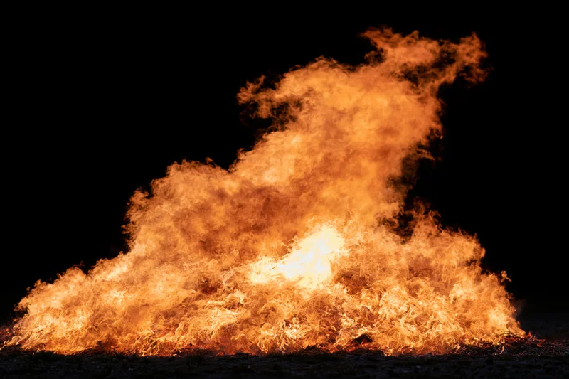 Intense fire burning brightly against a black night background