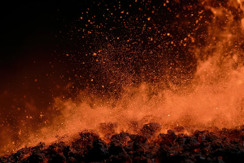 Intense fire burning at night with flying sparks and glowing embers