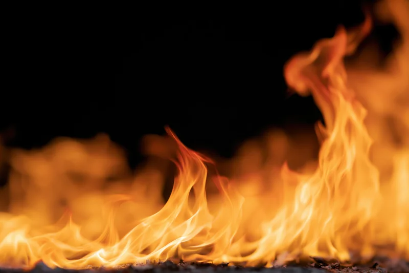Intense flames burning along the bottom and right edge against a dark background