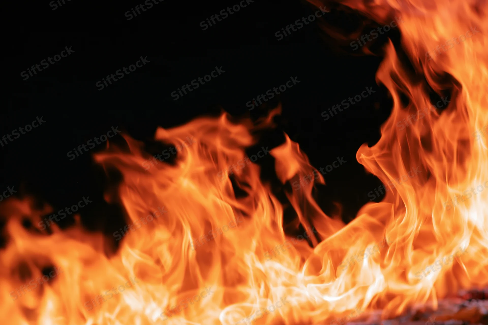 Intense flames burning along the bottom and right edge against a black background