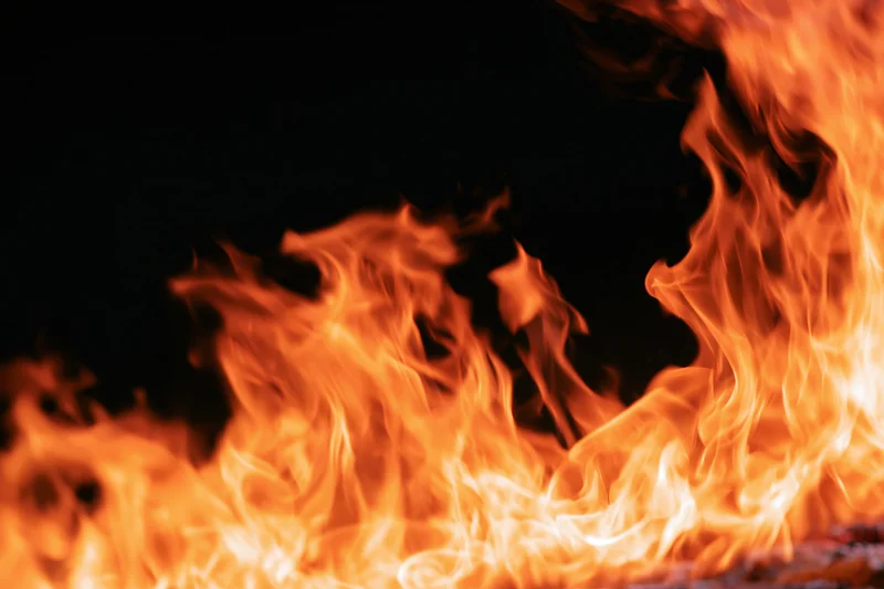 Intense flames burning along the bottom and right edge against a black background