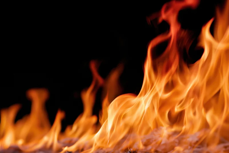 Intense flames burning along the bottom and right side against a dark background