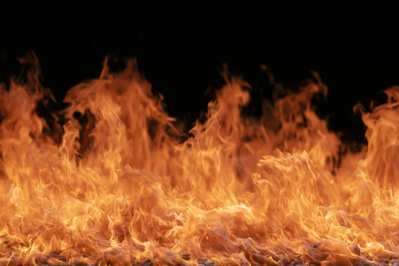 Intense flames burning across the frame against a black background