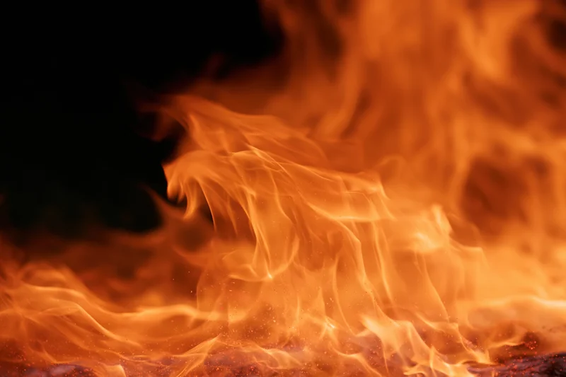 Large open flames rising intensely with bright orange tongues of fire filling the frame