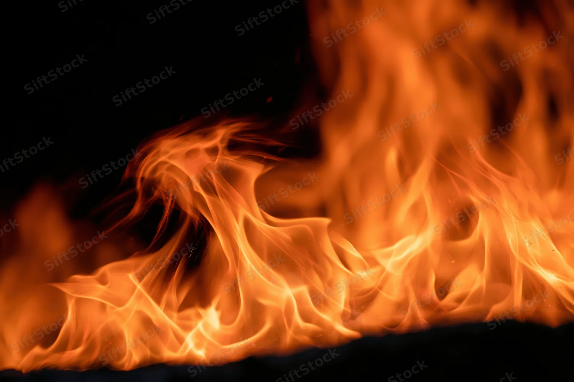 Large open flames rising dynamically against a dark background