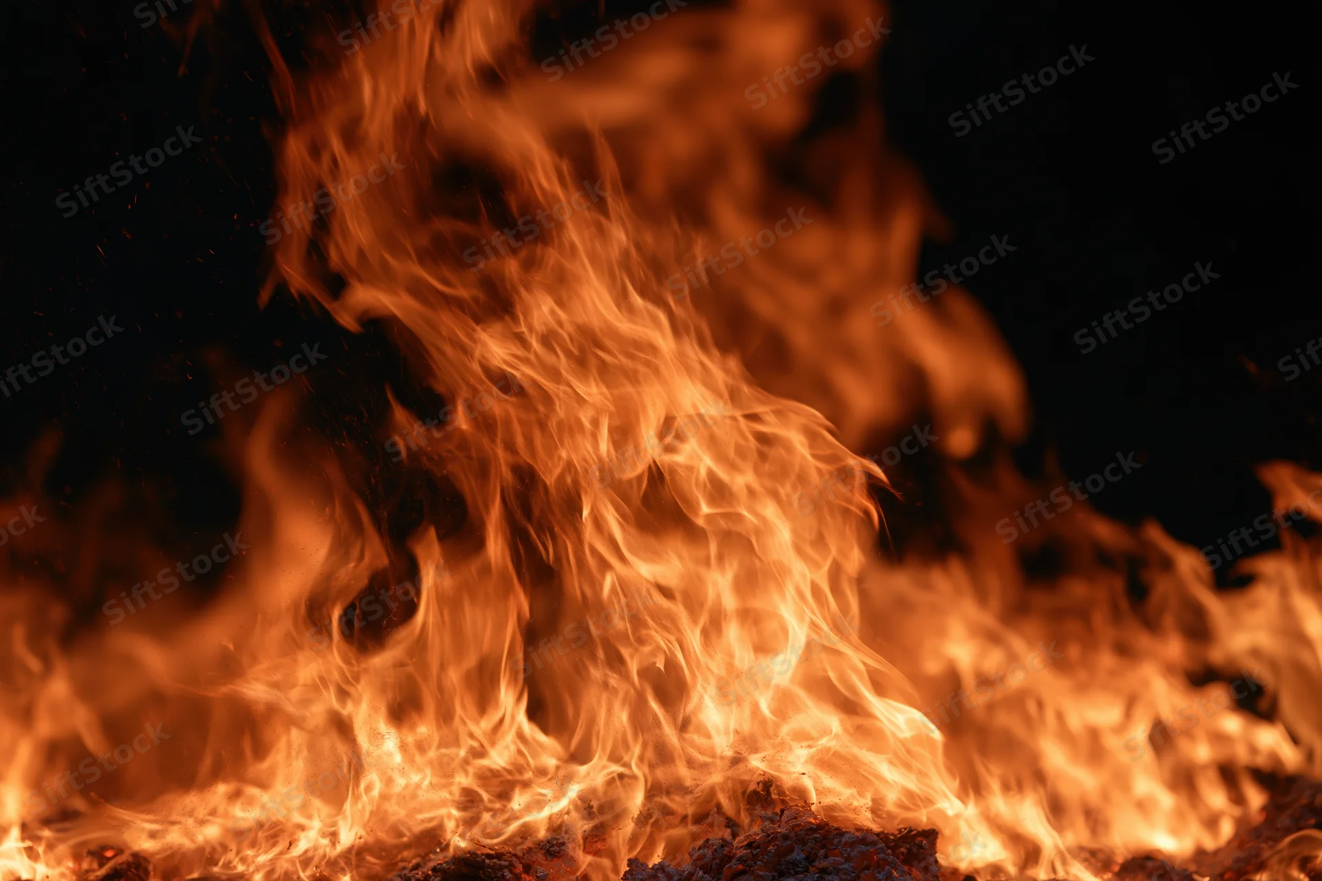 Large flames rising intensely against a dark background