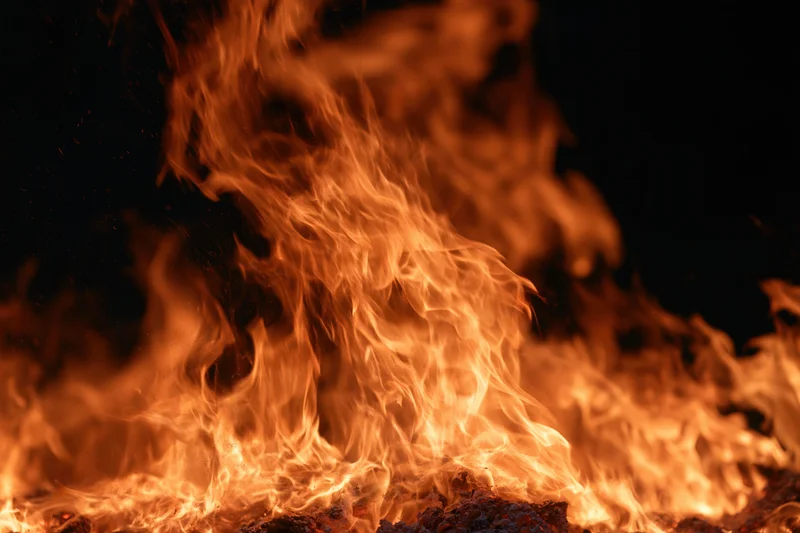 Large flames rising intensely against a dark background