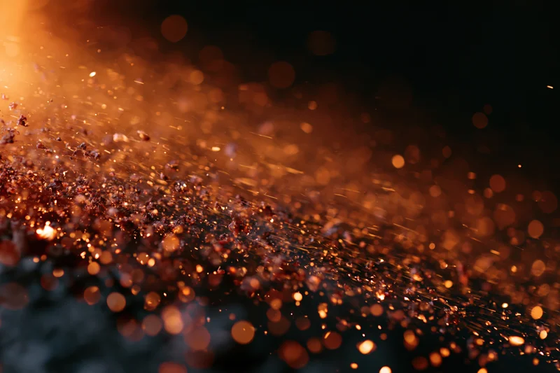Glowing sparks and embers floating in mid-air against a dark background