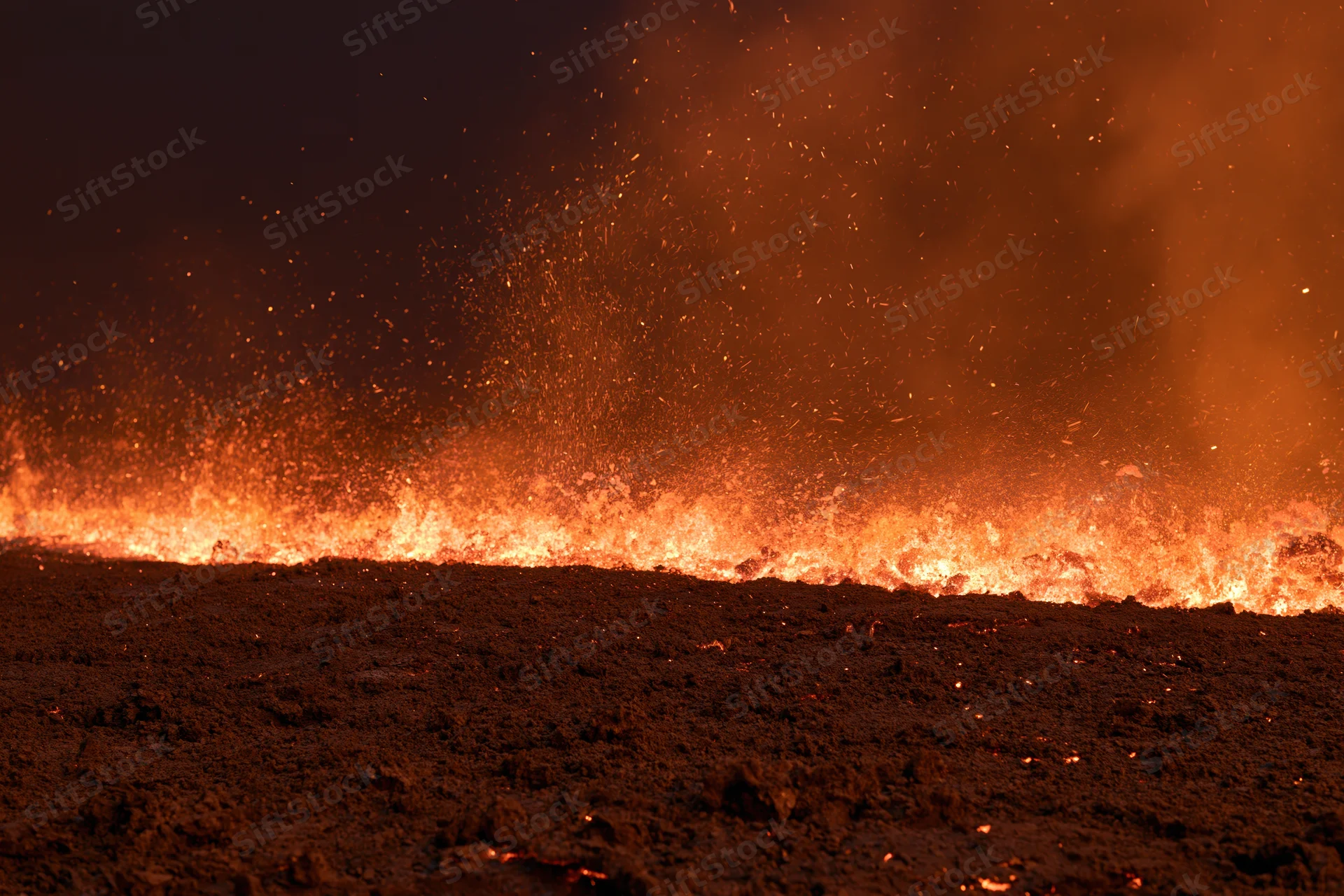Wildfire burning across scorched earth at night