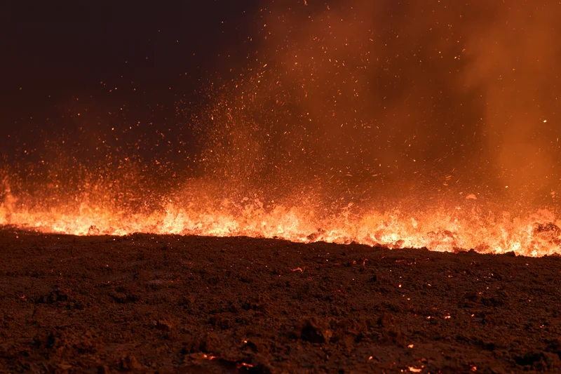 Wildfire burning across scorched earth at night