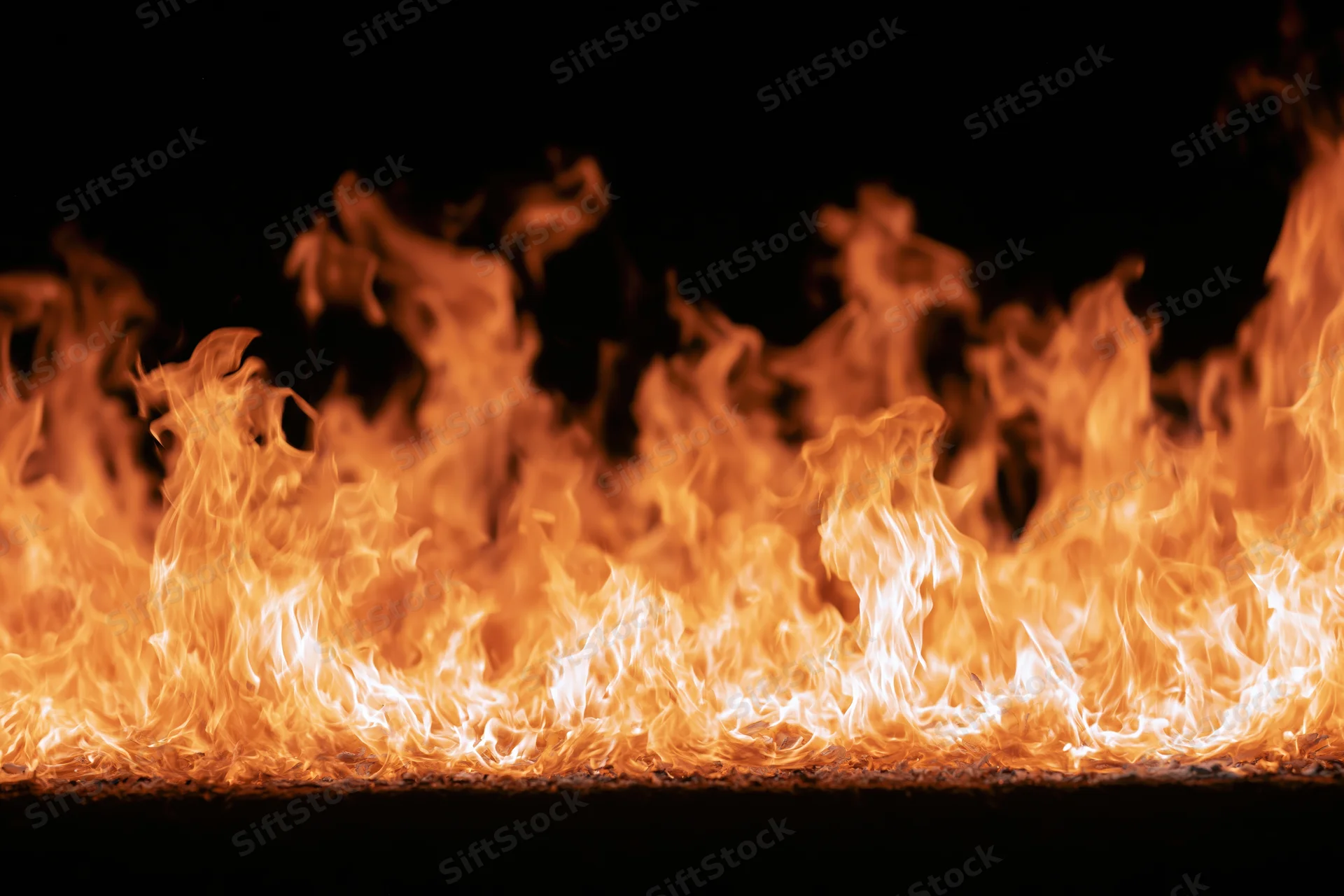 Intense flames burning vigorously against a pure black background
