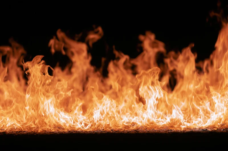 Intense flames burning vigorously against a pure black background
