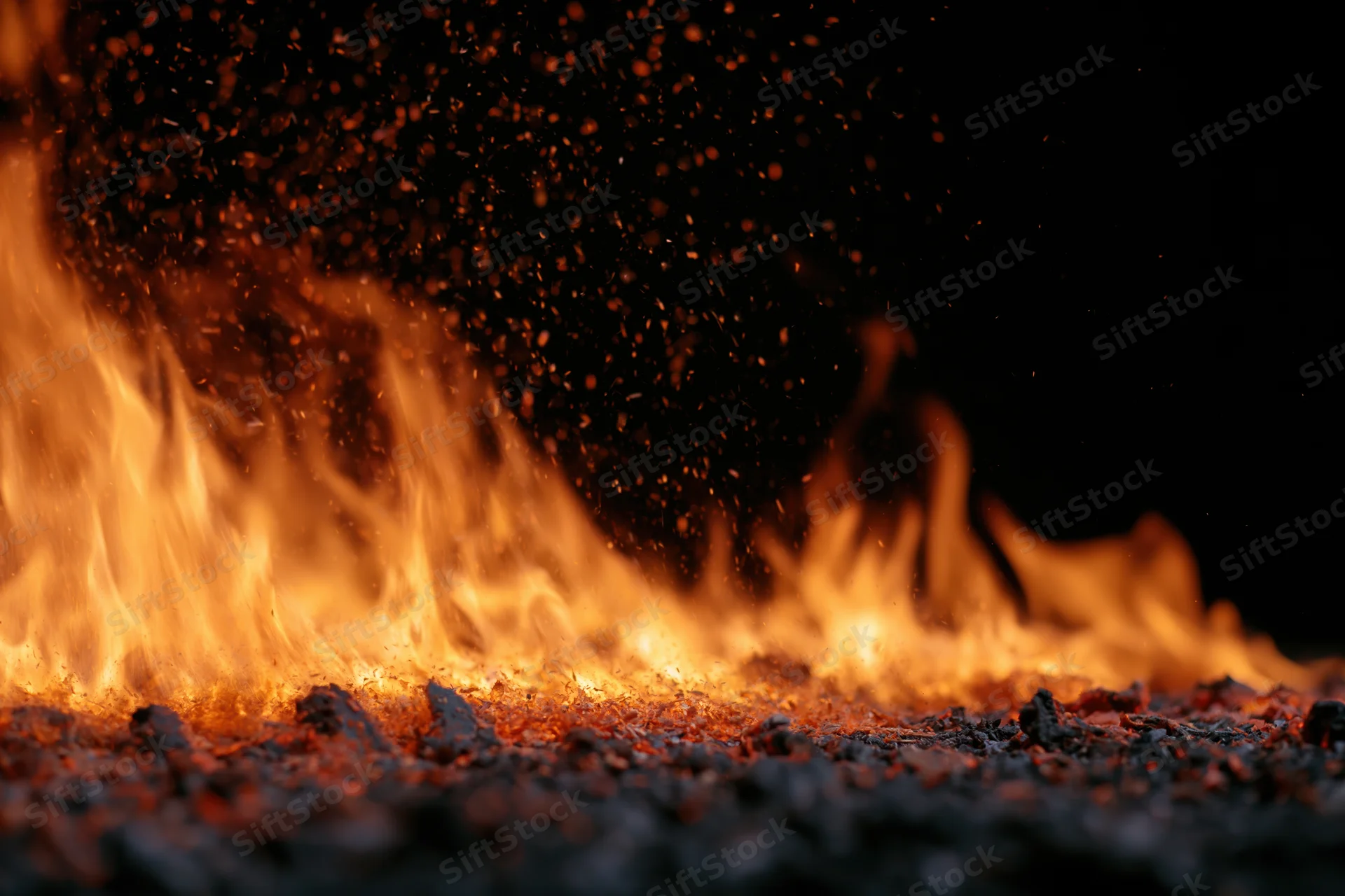 Flames burning with flying sparks on a black background