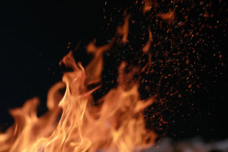 Flames burning with sparks against a black background