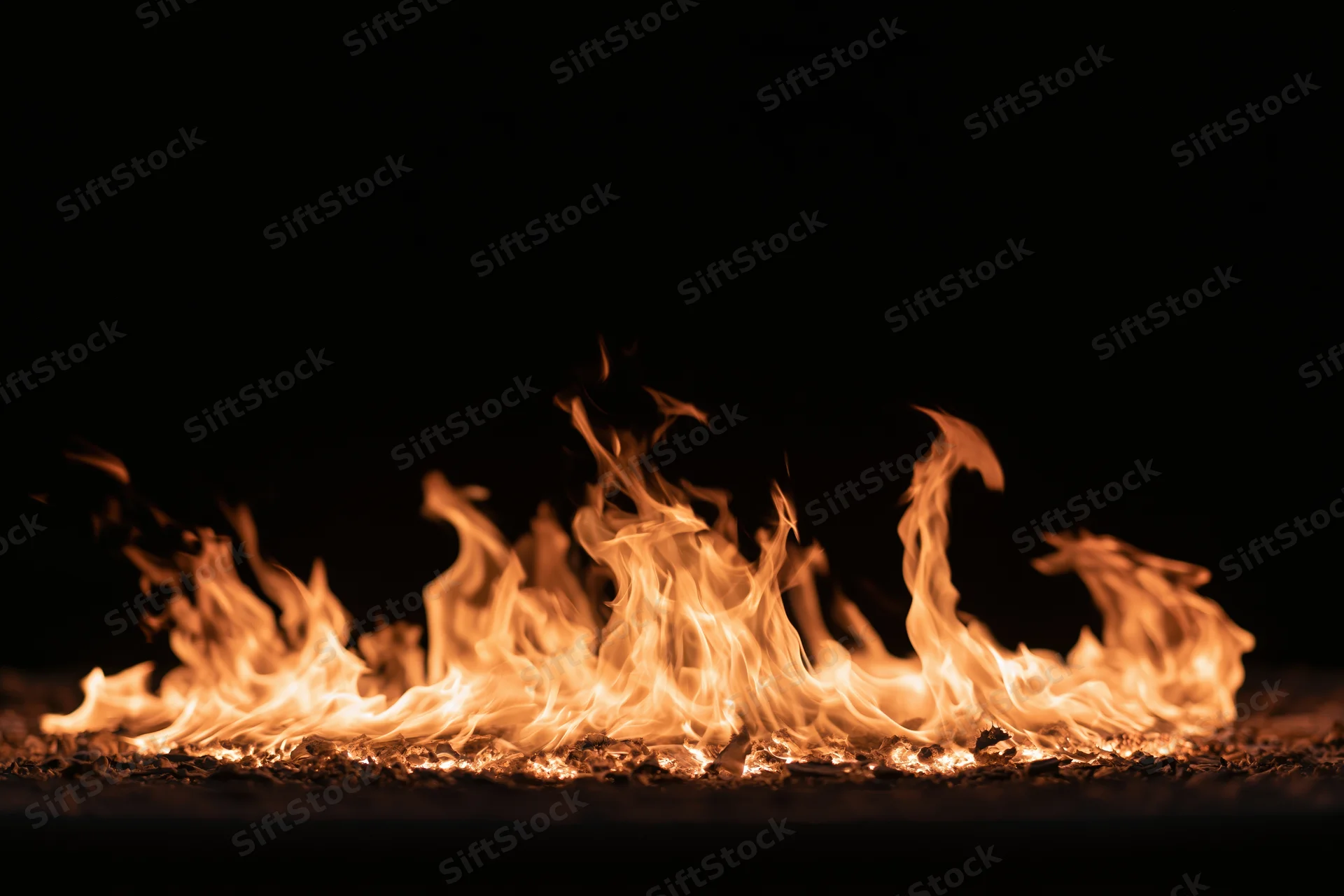 Flames burning low against a pure black background