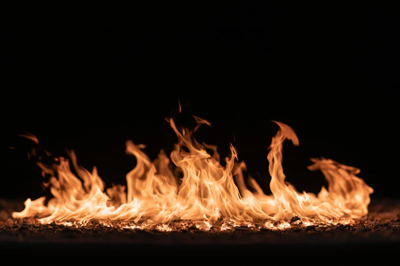 Flames burning low against a pure black background