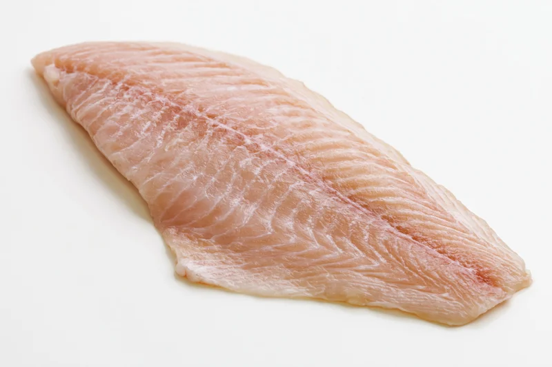 Raw white fish fillet laid flat on white background