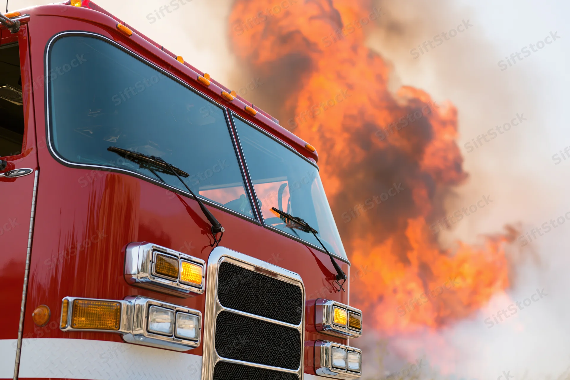 Red firetruck front quarter view with flames and smoke in background