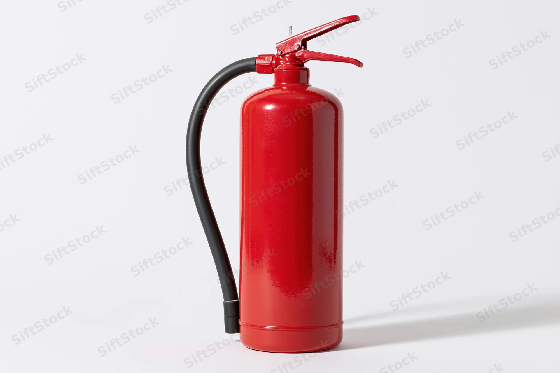 Red portable fire extinguisher standing upright on a white background