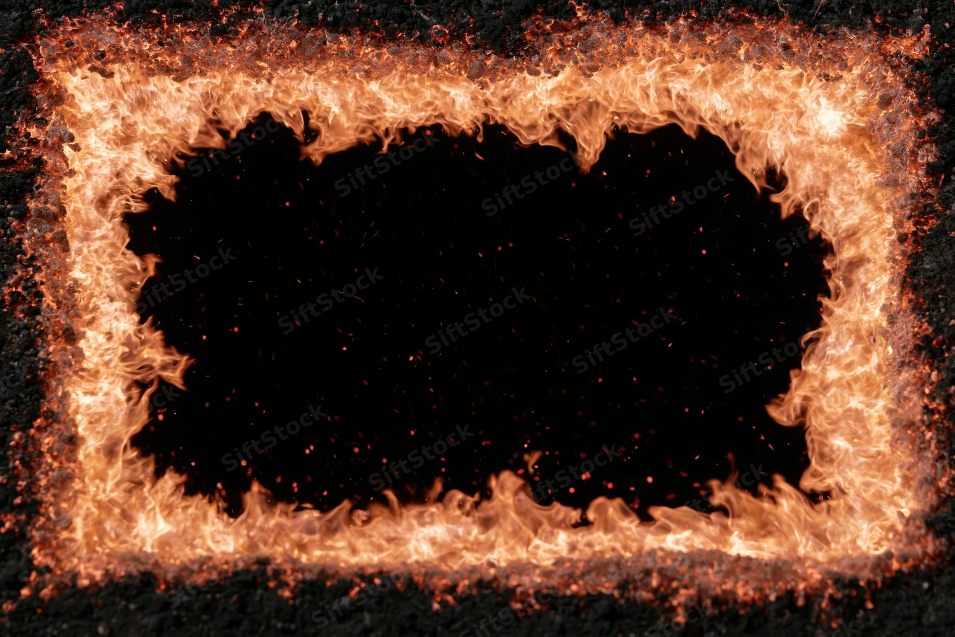 Rectangular frame of flames burning around a dark center with sparks and embers