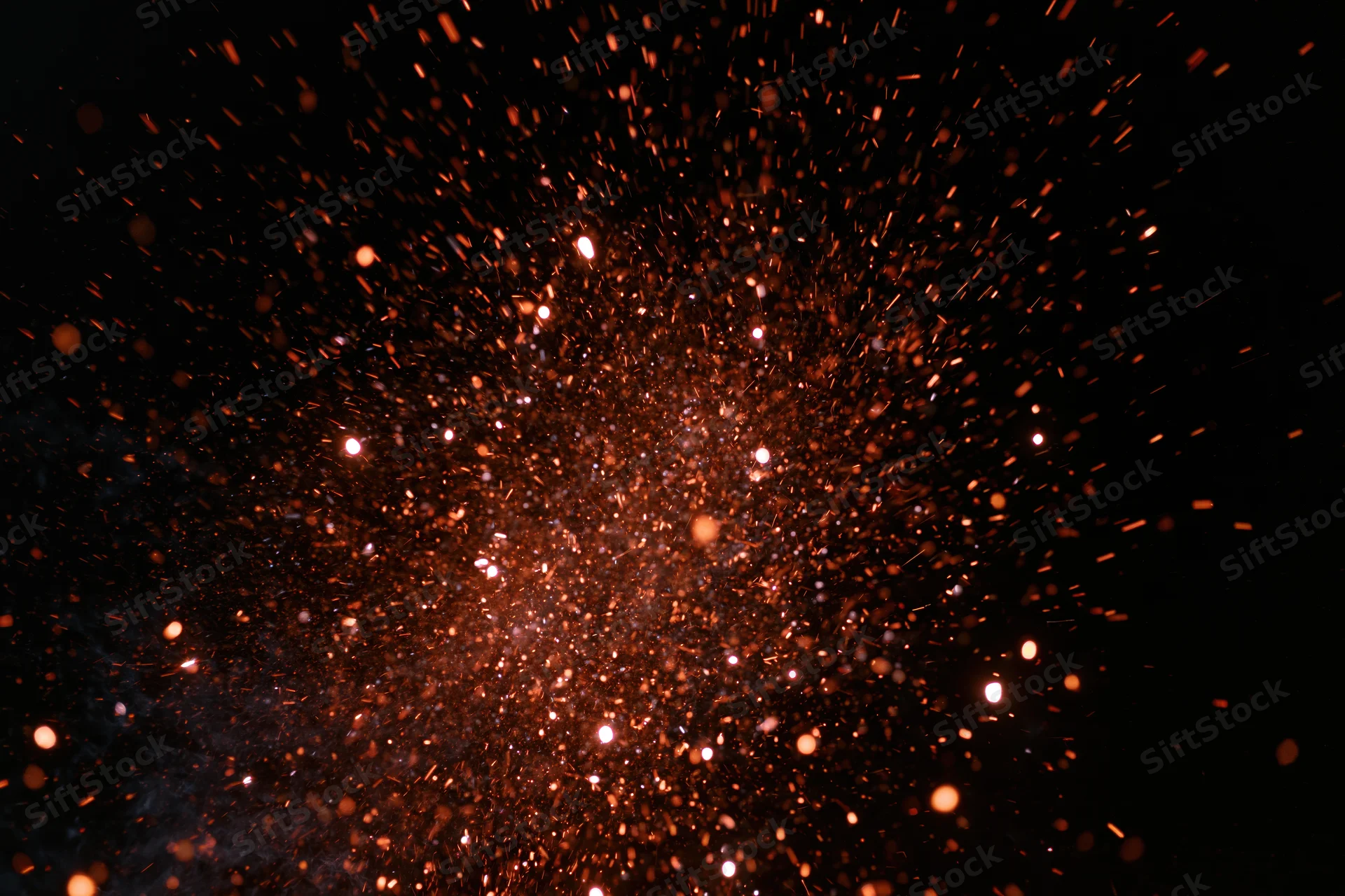 Glowing orange sparks bursting outward against a dark background