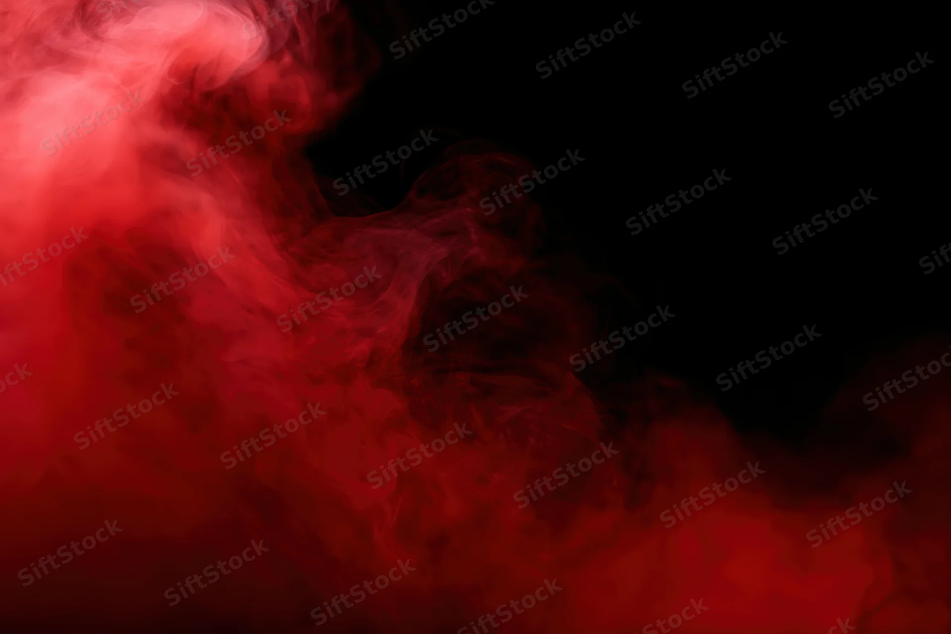 Swirling red smoke illuminated against a dark background