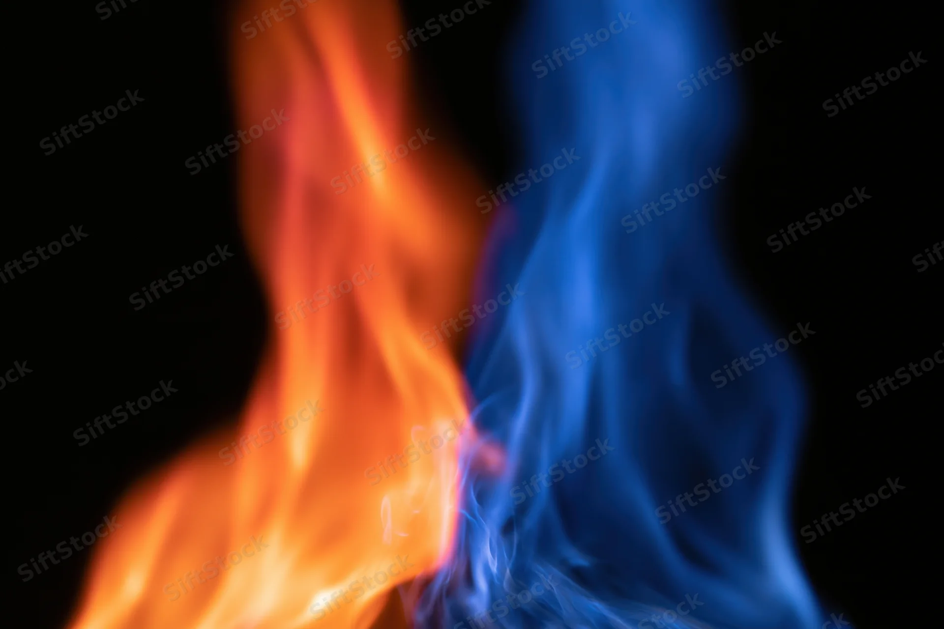 Two opposing columns of orange and blue flame burning against black background