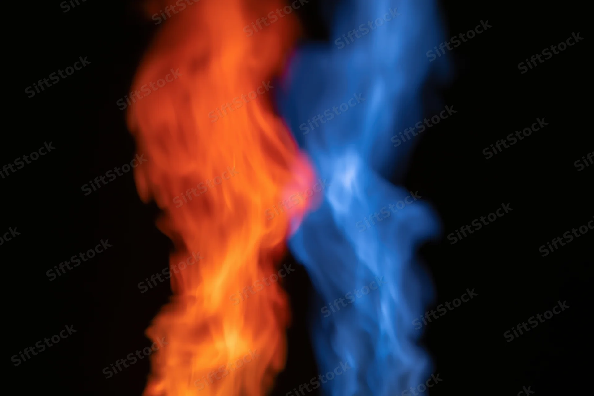 Two opposing columns of orange and blue flame rising against black background