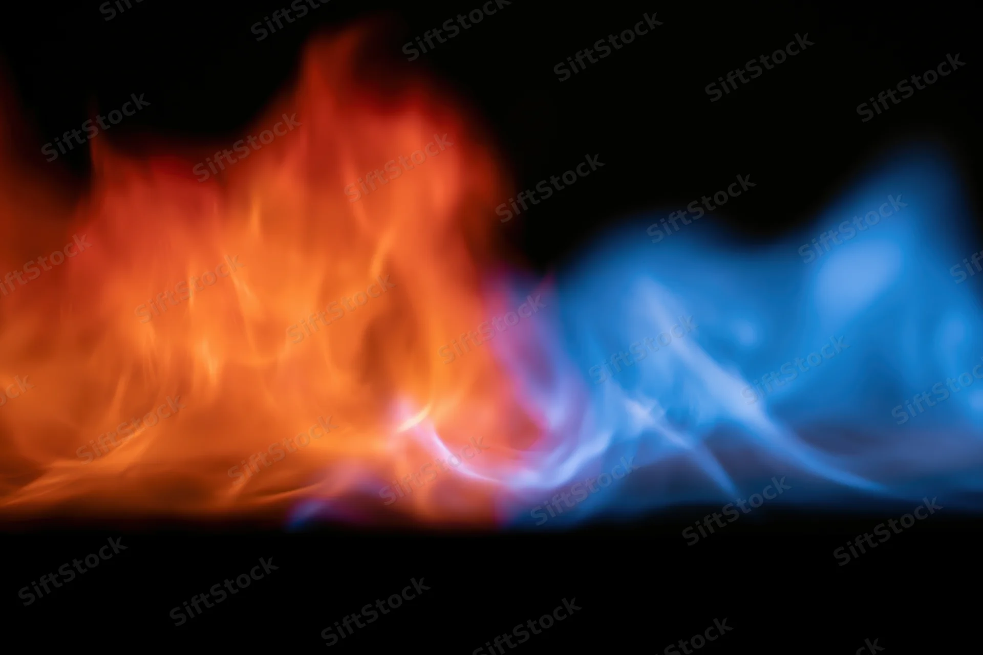Orange and blue flames burning side by side against black background