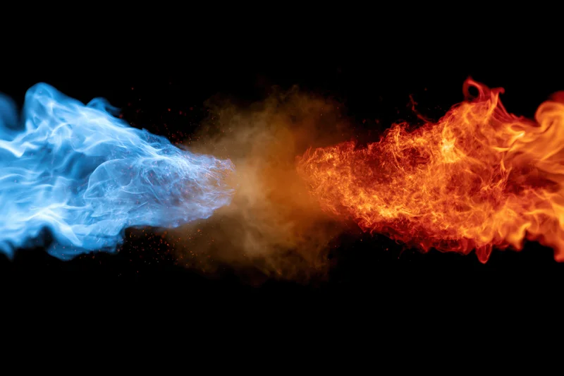 Blue and orange flames colliding in mid-air against black background