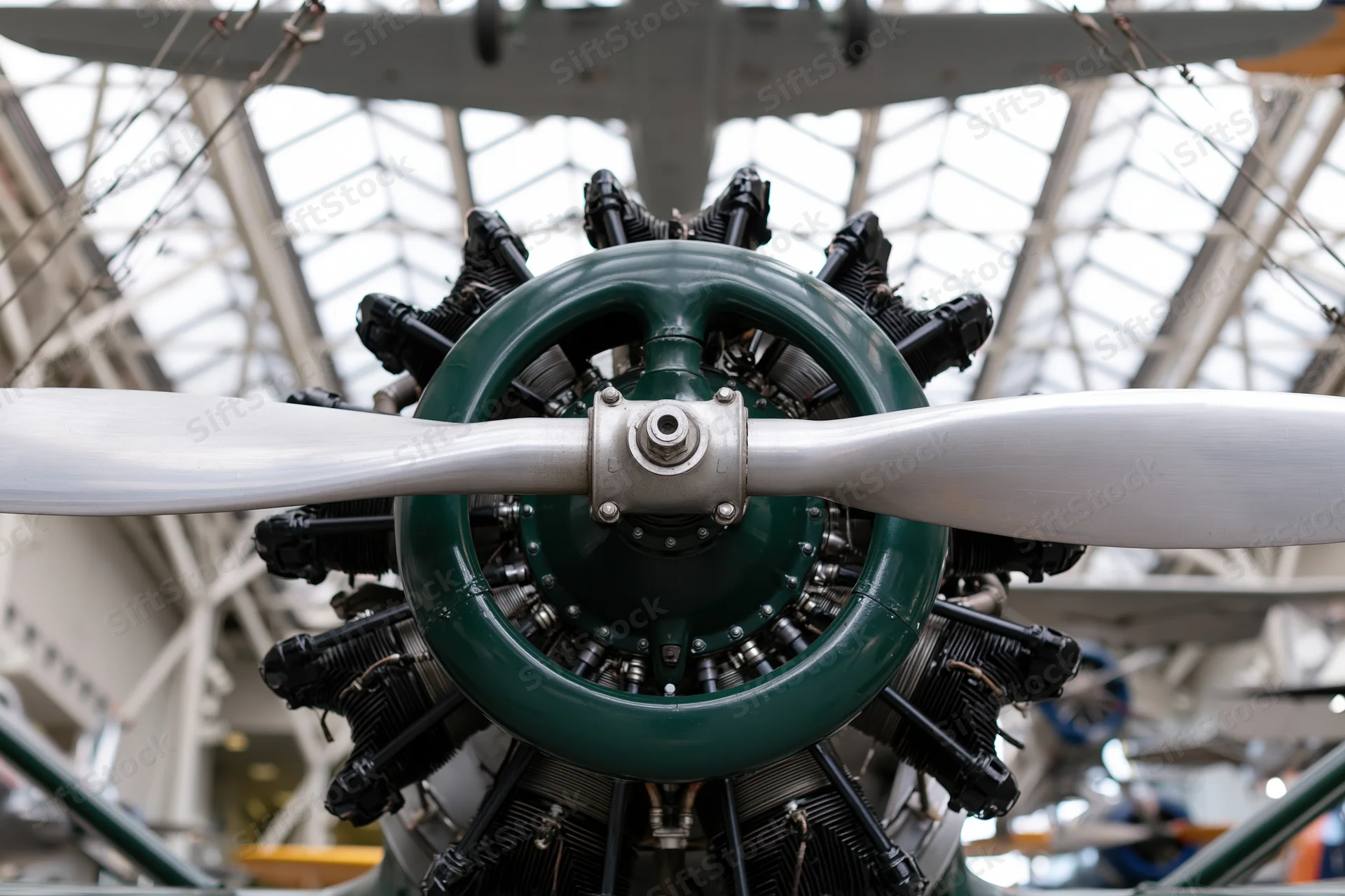 Vintage radial aircraft engine with two-blade metal propeller on display in a museum hall