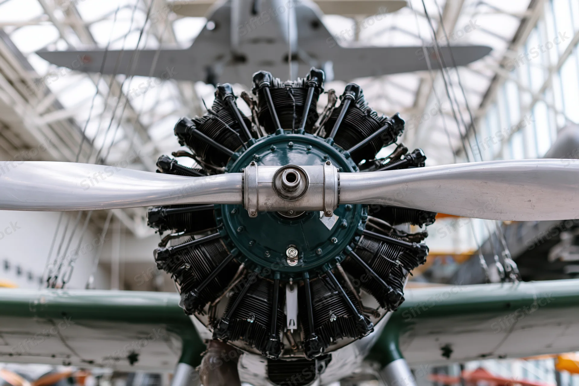 Vintage radial aircraft engine with two-blade metal propeller on display in a museum interior