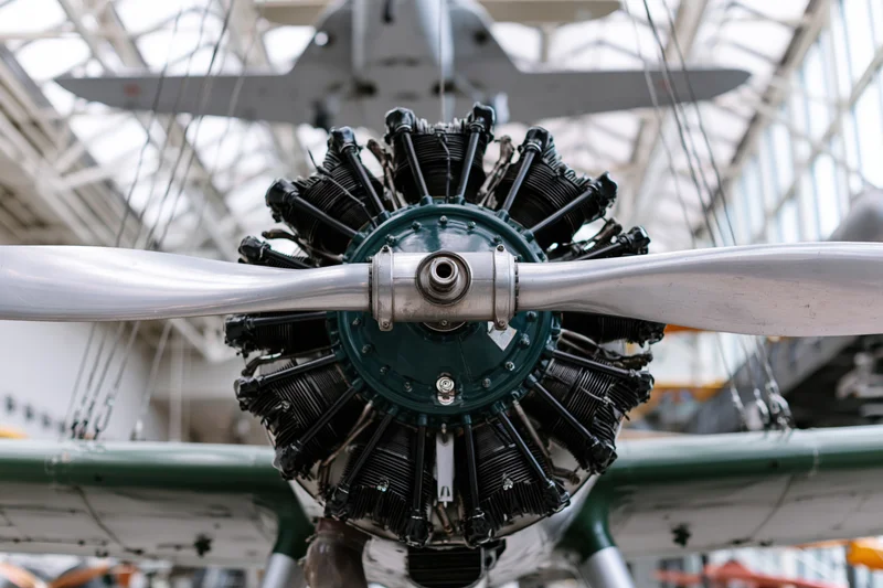 Vintage radial aircraft engine with two-blade metal propeller on display in a museum interior